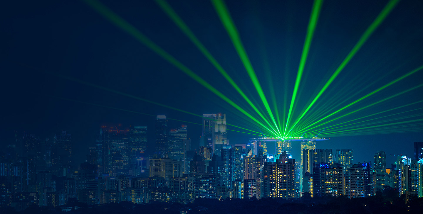 View of the city skyline with bright green lights beaming out from a building