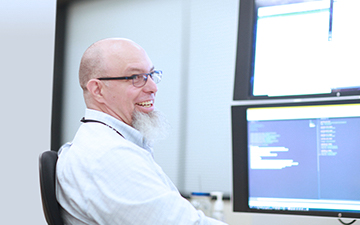 Defense customer sitting at computer smiling