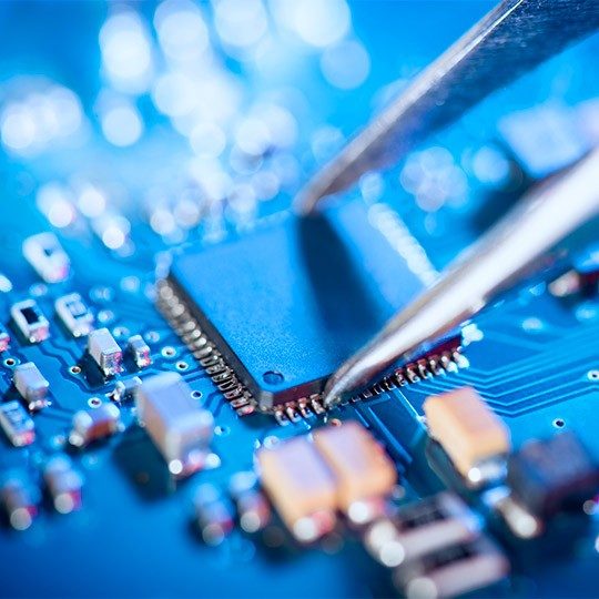Close-up image of tweezers grabbing onto a semiconductor